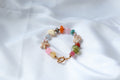 Handgemaakte armband Norah met glaskralen, resin en natuursteen in pastelkleuren met goudkleurige toggle sluiting